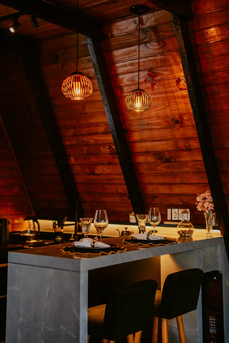 Bancada da cozinha com luminárias pendentes e mesa posta