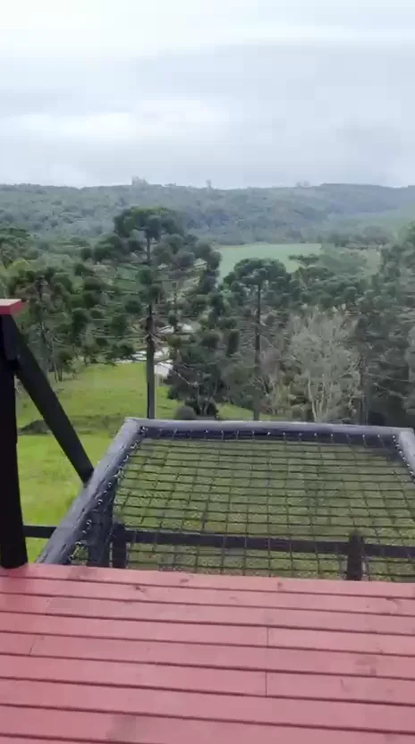 Deck de madeira do chalé com vista para o vale e as araucárias