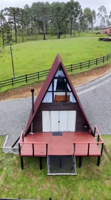 Chalé visto do gramado, com cerca de madeira